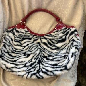 Faux zebra with faux red alligator trim and handles. Zip closure.